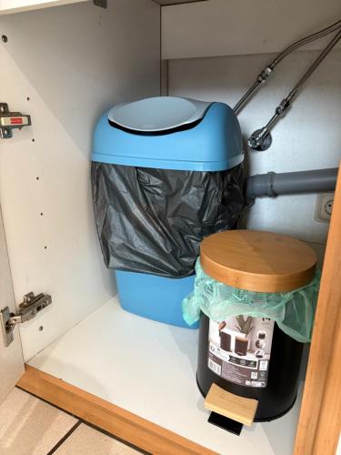 a trash can with a trash bag next to a bucket at Boho & Loft 2 Zimmer Parkplatz in Bad Hersfeld