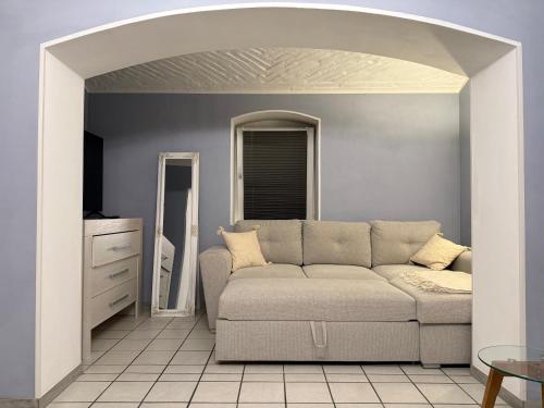 a living room with a couch and a mirror at Boho & Loft 2 Zimmer Parkplatz in Bad Hersfeld