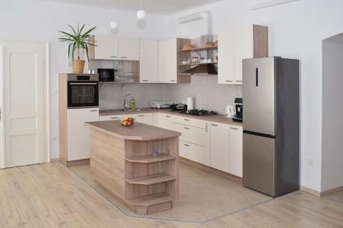 a kitchen with white cabinets and a refrigerator at Apartma Majerhold in Mozirje