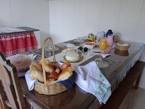 a table with a basket of bread on it at Chalés Vitória in Cunha