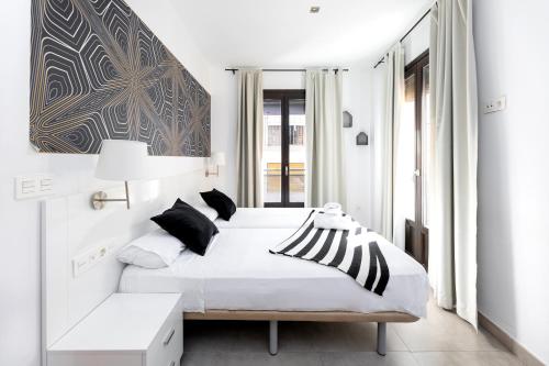 a bedroom with a bed with black and white pillows at Nest Flats Granada in Granada