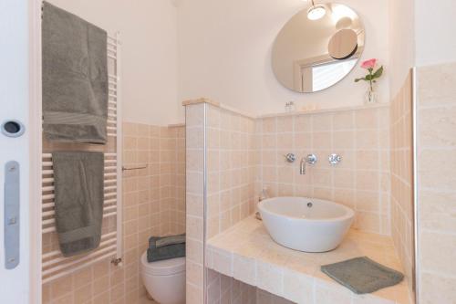 a bathroom with a sink and a toilet and a mirror at I Sette Ulivi in Laiatico