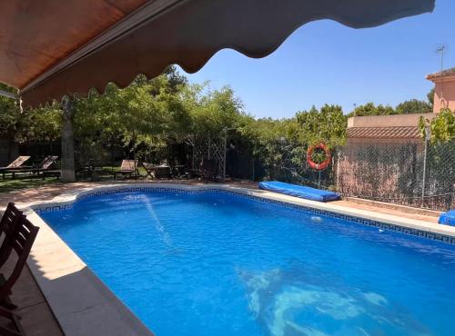 una piscina con acqua blu in un cortile di Apto con piscina y barbacoa a La Alcayna