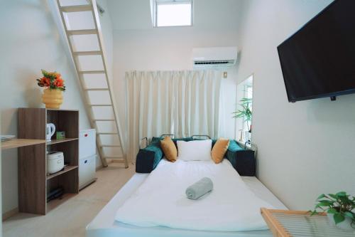 a small room with a bed and a television at Home Story in Tokyo Kanametyo-Ikebukuro-Ginzaまで直通&東京屋語 in Tokyo