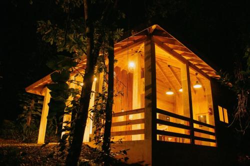a wooden cabin with a lit up door at night at Indómito Chalet-El Yunque Zone in Juncos