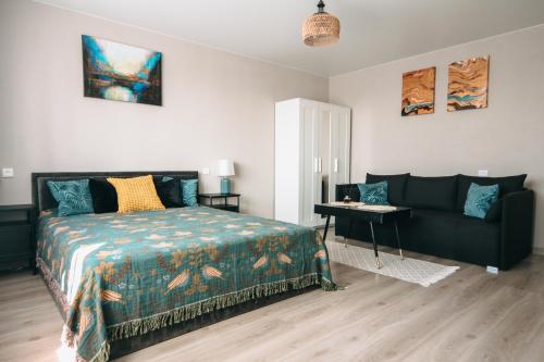 a bedroom with a bed and a couch at Central Park Apartment in Šiauliai