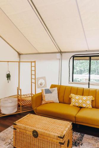 a living room with a couch and a large window at The Goldfinch's Nest - Glamping Tent with AC in Rogers
