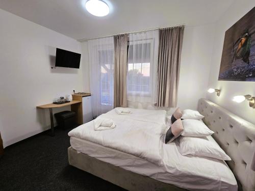a hotel room with a bed and a window at Heléna Hotel & SPA in Levél