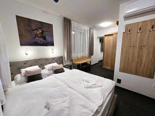 a bedroom with a large white bed in a room at Heléna Hotel & SPA in Levél