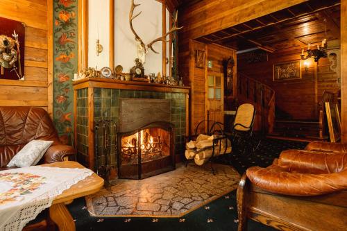 a living room with a fireplace in a log cabin at Rezydencja Karpatka in Karpacz