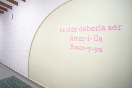 a white wall with a sign that reads laida detrizia set amazon at Hotel Chromatic in Guatapé