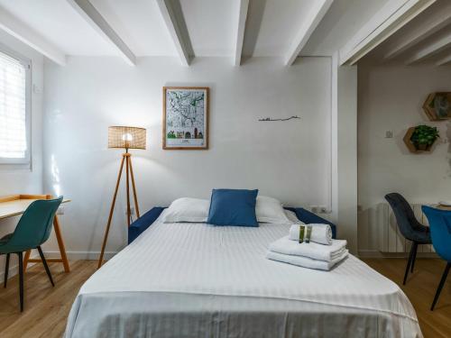 a bedroom with a bed with blue chairs and a desk at Cocon Tête d'or in Lyon