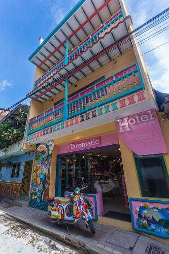 a store with a motorcycle parked in front of it at Hotel Chromatic in Guatapé