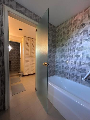 a bathroom with a tub and a tile wall at Brezza sul Colle in Montesilvano