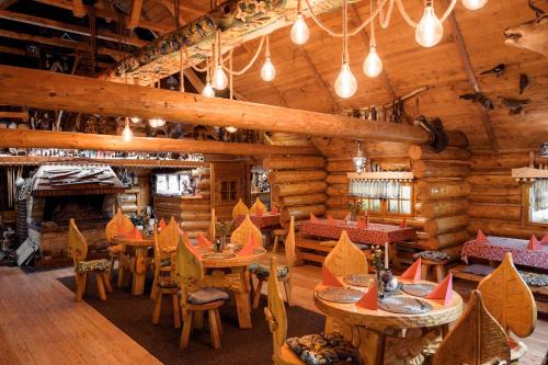 a dining room with tables and chairs in a log cabin at Rezydencja Karpatka in Karpacz