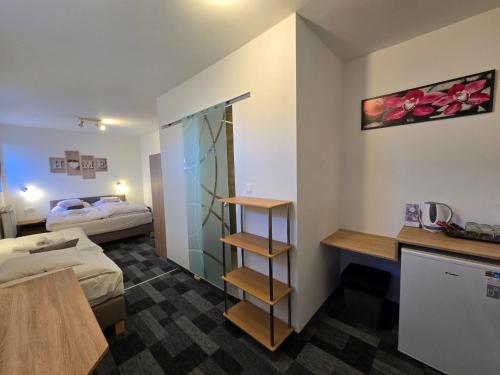 a hotel room with a bedroom with a bed and a desk at Heléna Hotel & SPA in Levél