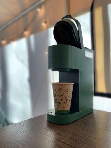 a coffee machine sitting on a table with a cup at The Goldfinch's Nest - Glamping Tent with AC in Rogers