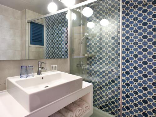 a bathroom with a sink and a shower at Hotel Caleta in Lloret de Mar