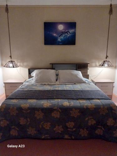 a bedroom with a bed with two lights above it at Angel's Appt in Rivière Noire