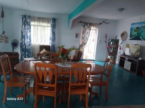 a dining room with a wooden table and chairs at Angel's Appt in Rivière Noire