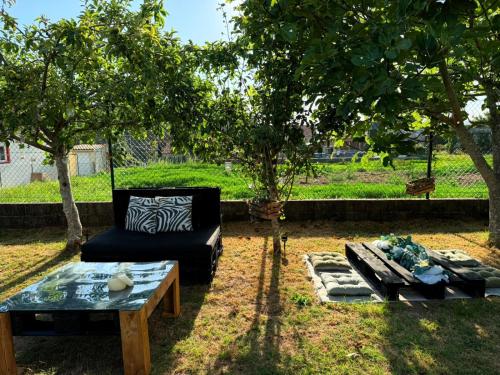 a couch and a table in a yard with trees at Casa Miñortos in Miñortos