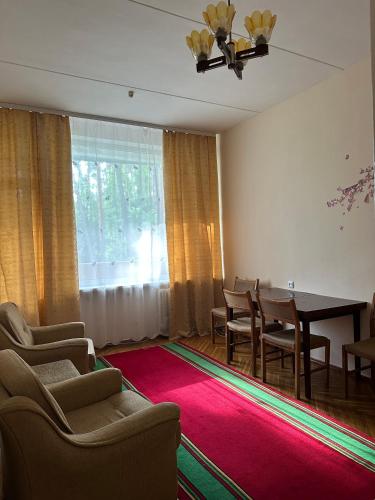 a living room with a table and chairs and a red rug at GREENMIST apartaments in Kyiv