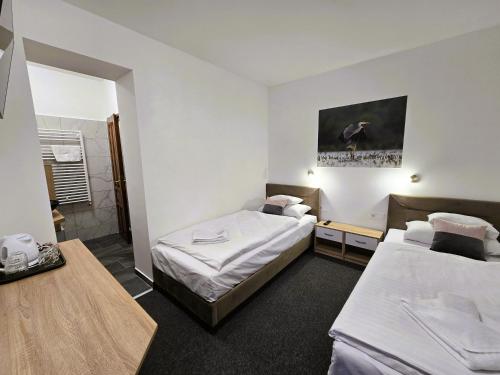 a hotel room with two beds and a table at Heléna Hotel & SPA in Levél