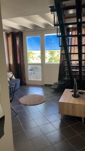 a living room with two windows and a tiled floor at Loft a deux pas des Remparts in Avignon