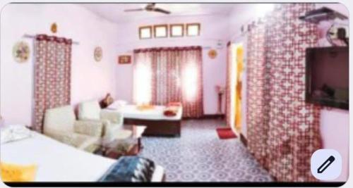 a living room with a couch and a tv at Sreemoyee Homestay in Hatikhuli