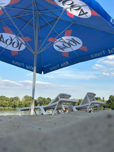 a blue umbrella sitting on a beach with chairs at GREENMIST apartaments in Kyiv
