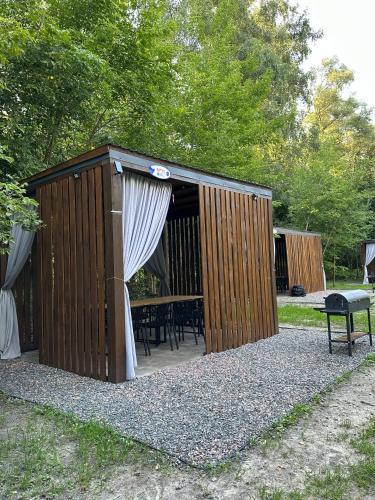 a wooden shed with a table and a curtain at GREENMIST apartaments in Kyiv