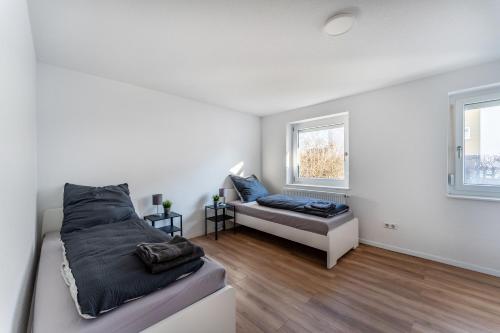 una camera da letto bianca con un letto e un divano di Monteur- & Gästewohnung mit Küche, WLAN & Parkplatz - SCH04 a Schramberg