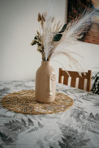 a vase with feathers in it sitting on a table at Podlesanka Vysoké Tatry in Smokovce