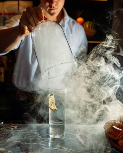 a person is stirring a glass with smoke at BULL Burford in Burford