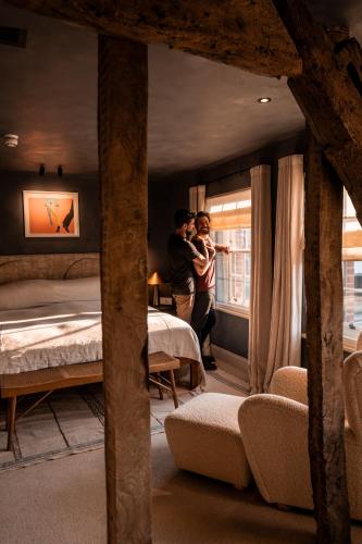 two people standing in a bedroom with a bed at BULL Burford in Burford