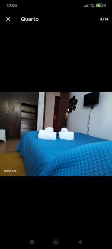 a bedroom with a blue bed with towels on it at Casa da Ruben Lisboa in Lisbon