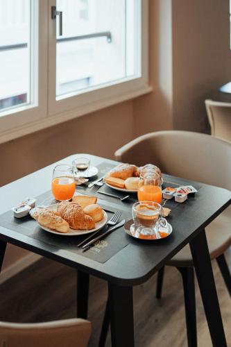 a table with plates of food and glasses of orange juice at Central Suites in Chieti