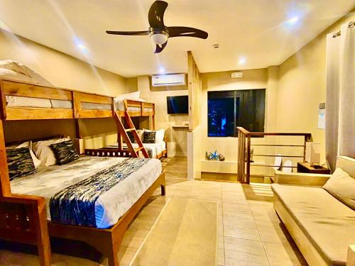 a bedroom with two bunk beds and a ceiling fan at Southseas Beach Resort and Dive Center in Santander
