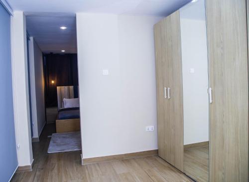 a room with a door and a bedroom with a bed at PLSA 1bedrooms at airport city in Accra