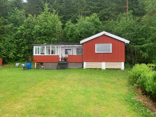 una casa rossa e bianca in mezzo a un cortile di Cabin at Hestsjøen Badeplass a Trondheim