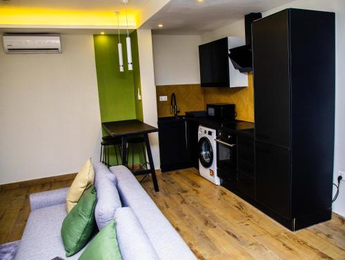 a living room with a couch and a kitchen at PLSA 1bedrooms at airport city in Accra