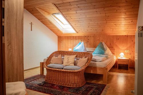 a room with a wicker chair and a bed at Ferienwohnung Schoberhof in Filzmoos
