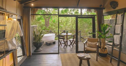 a screened in porch with a tub and a table at Hotel Casa Candela in San Jerónimo