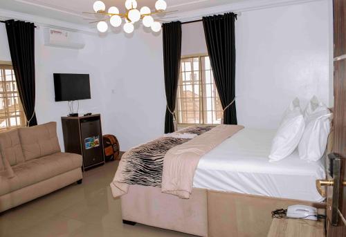 a bedroom with a large bed and a couch at Deluxe Indulgence Hotel & Suites in Mama