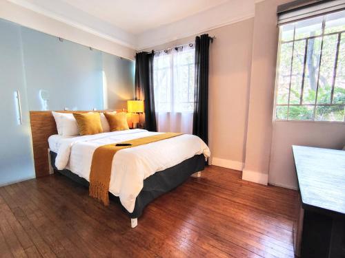 a bedroom with a large bed and a window at Casa Pánuco in Mexico City