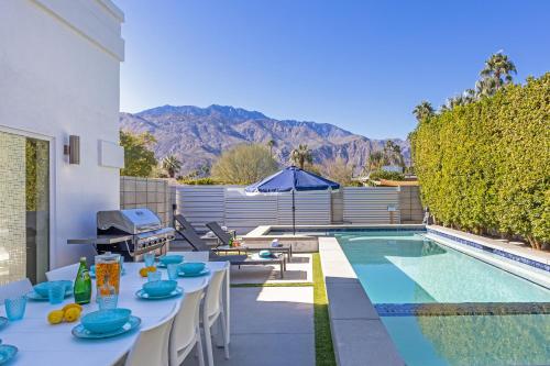 a patio with a table and a swimming pool at Royal Escape by ACME House Company in Palm Springs