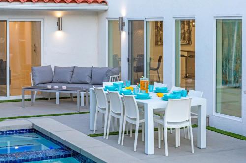 a white table and chairs next to a pool at Royal Escape by ACME House Company in Palm Springs