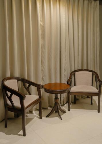 two chairs and a table and a table and chairs at Antilla By Alhanney in Guwahati