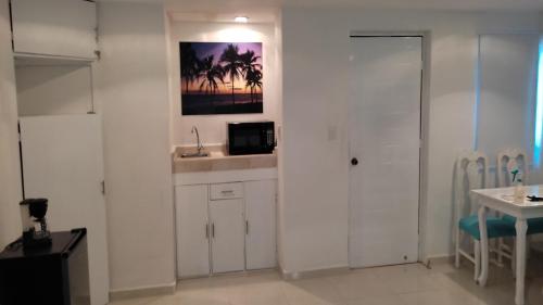 a white kitchen with a sink and a microwave at Cancun Blue Ocean in Cancún