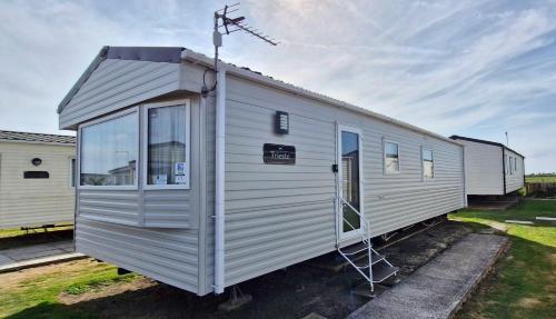 a white trailer is parked in a lot at Trieste, 2 Bedroom, 6 Berth Caravan, Seasalter in Seasalter